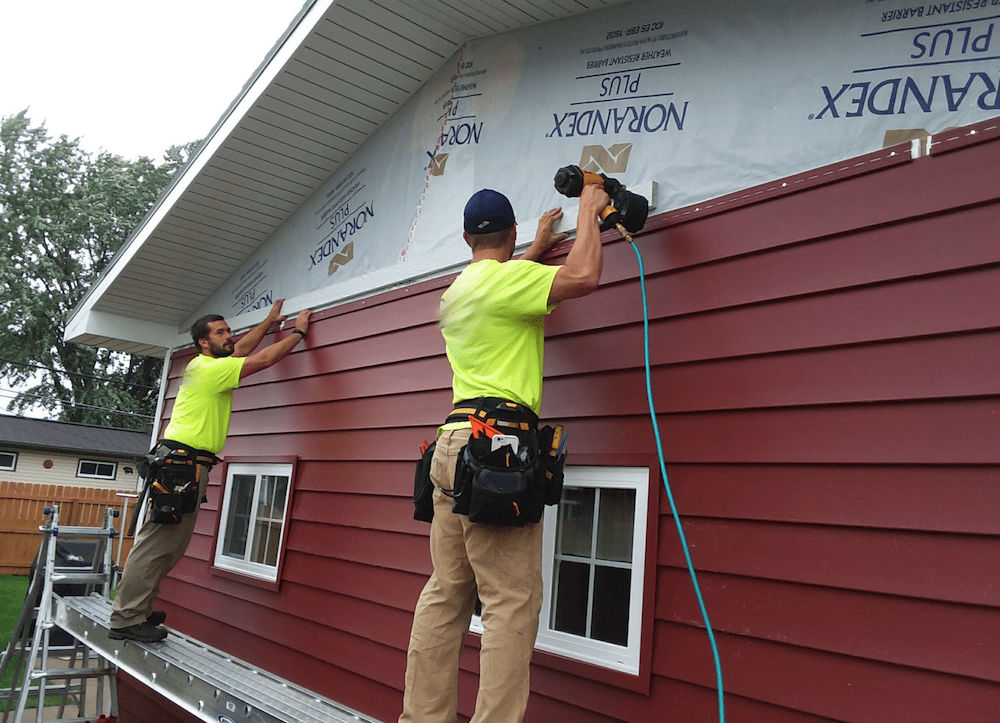 a crew installing siding on a house